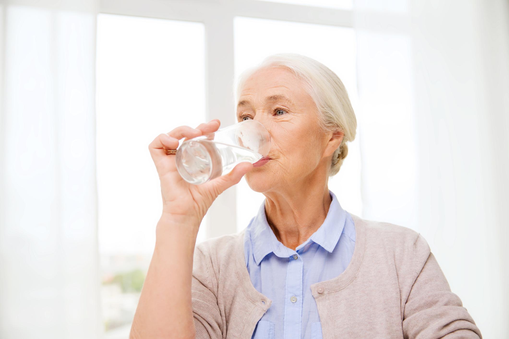 Сохнет во рту причины у пожилых. Женщина пьет воду. Бабушка пьет воду. Питье у пожилых. Пожилая женщина пьет воду.