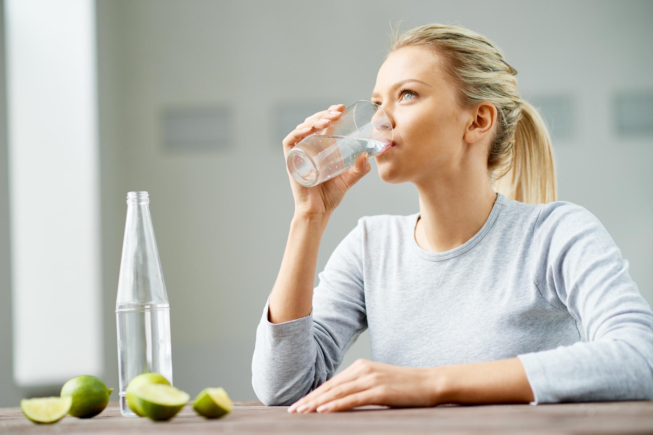 Запивать теплой водой. Обильное питье. Женщина пьет воду. Человек пьет воду из стакана. Питье воды.